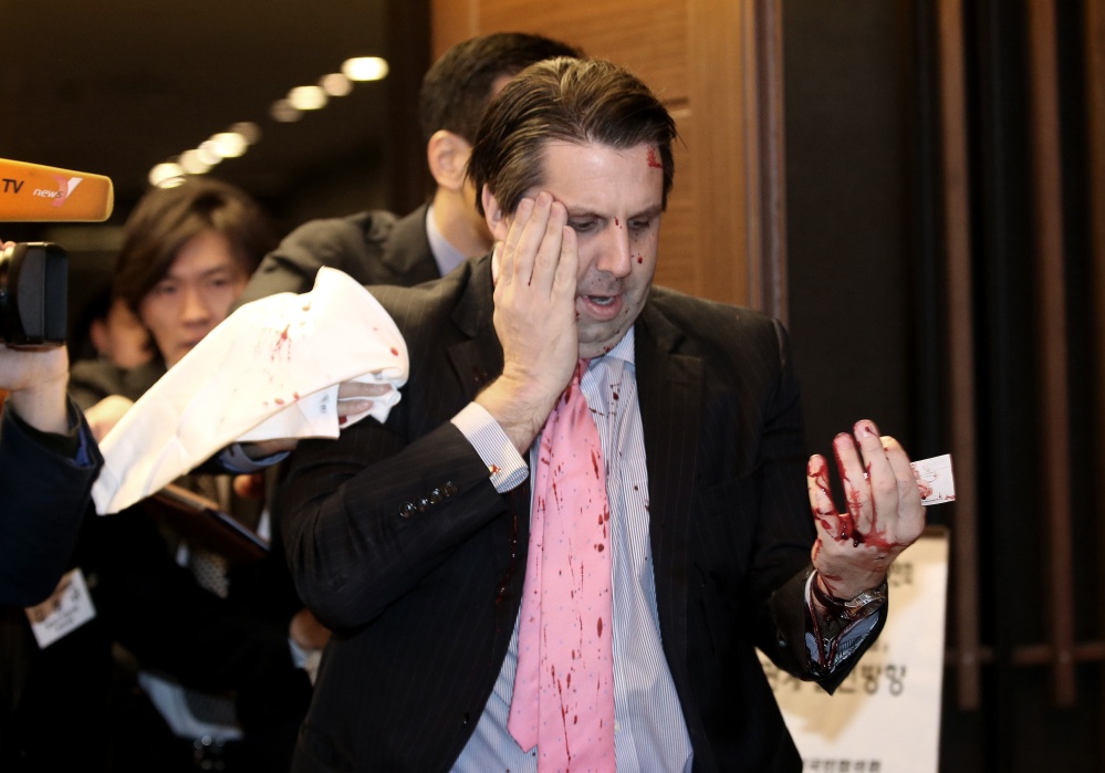 U.S. Ambassador to South Korea Mark Lippert leaves a lecture hall for a hospital in Seoul, South Korea, on Thursday after being attacked by a man screaming that the rival Koreas should be unified, South Korean police and media said Thursday