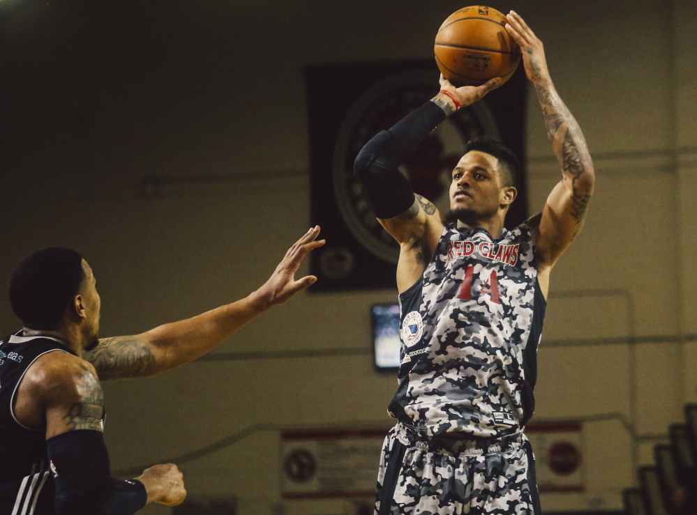 Red Claws forward Chris Babb makes a three-point shot while Spurs guard Orlando Johnson defends at the Expo Building in Portland on Thursday. Whitney Hayward/Staff Photographer
