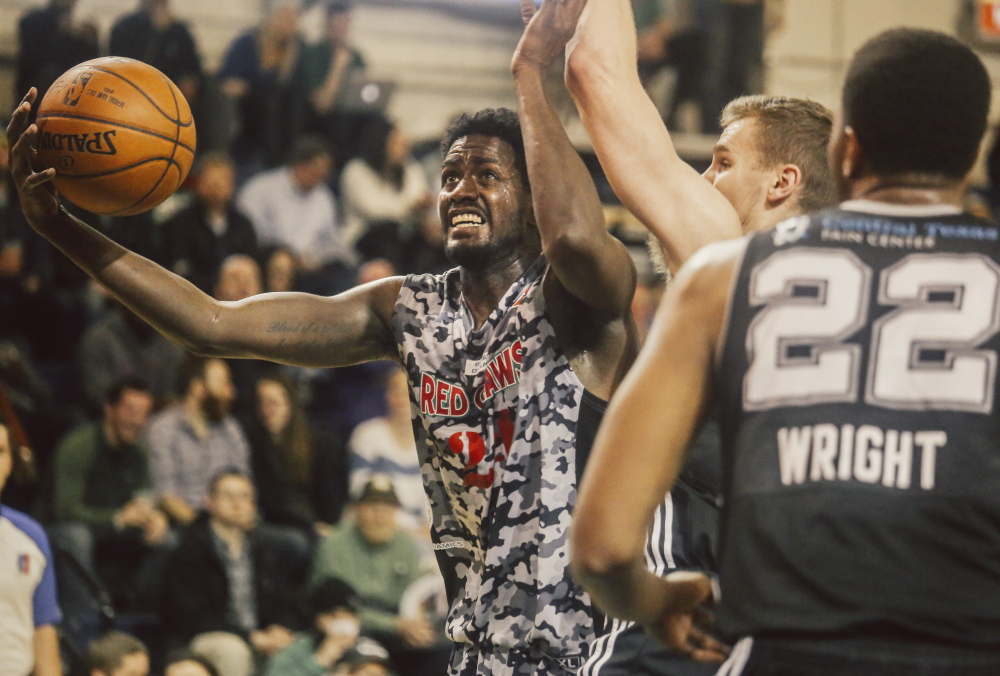Red Claws forward Omari Johnson goes for a layup as Spurs forward Erik Murphy, center, and forward Keith Wright defend at the Expo on Thursday. Whitney Hayward/Staff Photographer