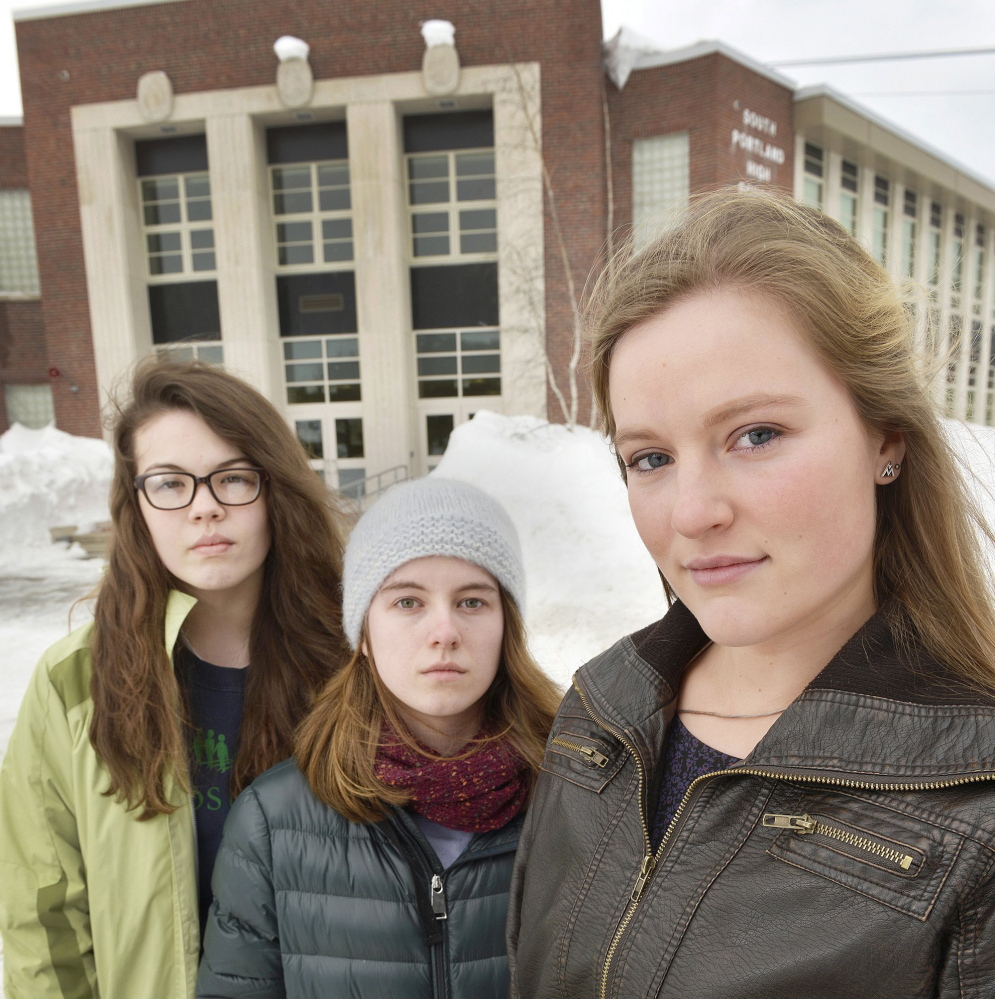 Lily SanGiovanni, right, is joined by Morrigan Turner, left, and Gaby Ferrell in front of South Portland High School, where they have let students and teachers know they don’t have to say the Pledge of Allegiance.