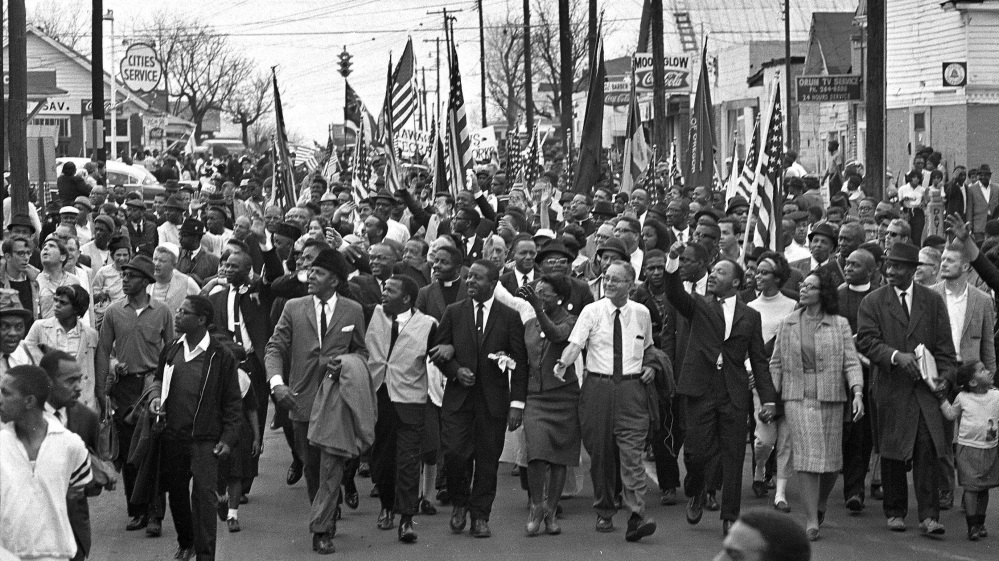 Martin Luther King, foreground row, waves with marchers on March 21, 1965 – an event that put Selma, Ala., on the map of the national conscience.