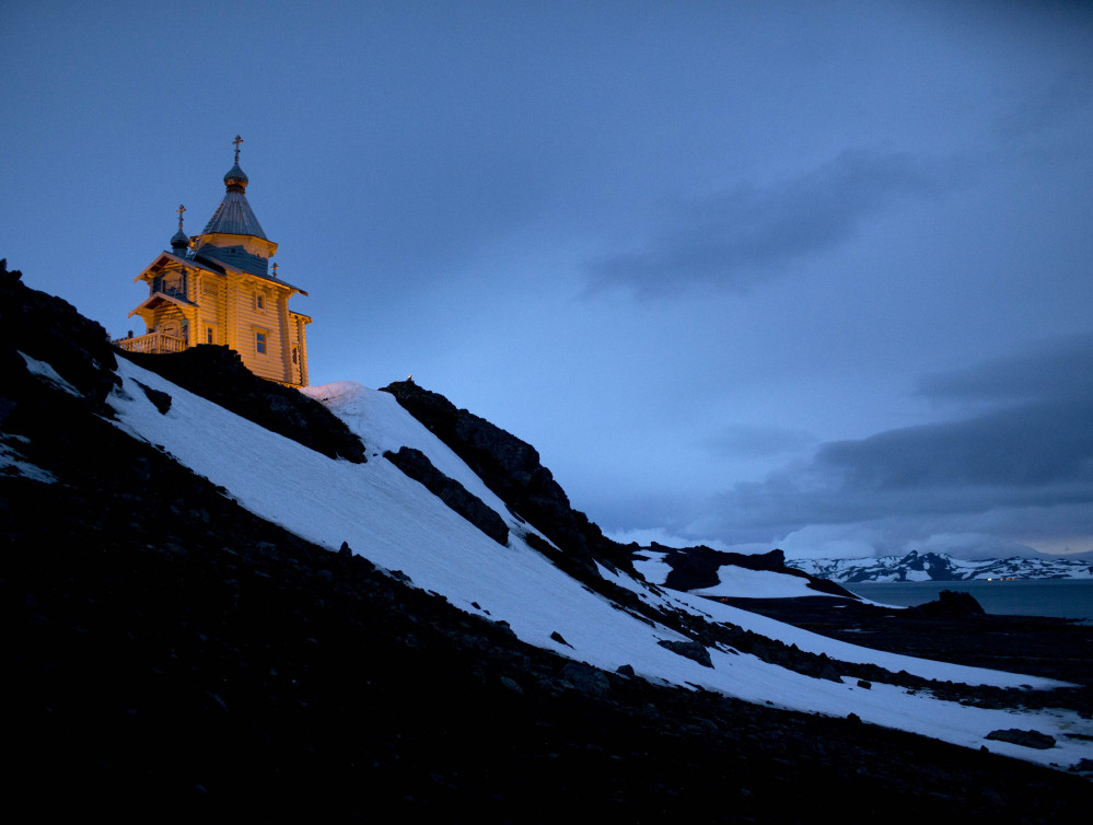 The Holy Trinity Church, perched on a rocky hill, is illuminated on King George Island, Antarctica. The Associated Press