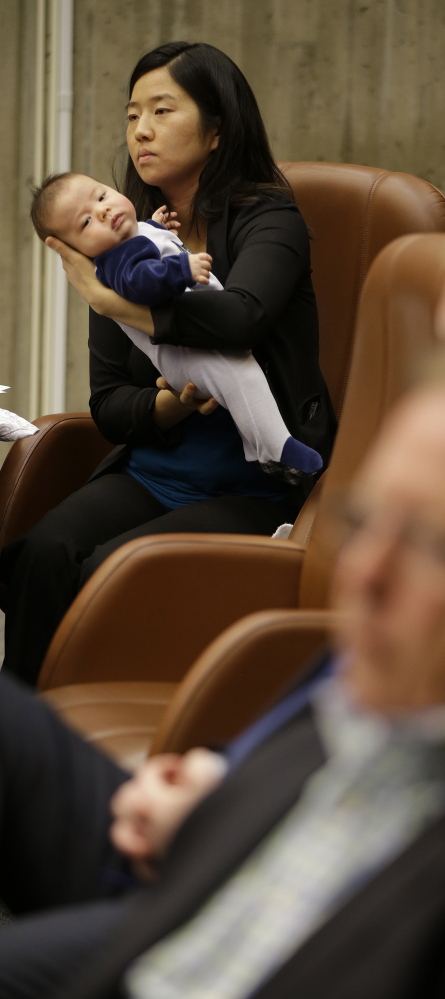 Boston City Councilwoman Michelle Wu holds her son Blaise Pawarski on Friday during a meeting to discuss the city’s bid for the 2024 Olympics. “Boston doesn’t need to host the Olympics to be a world-class city,” Wu said.