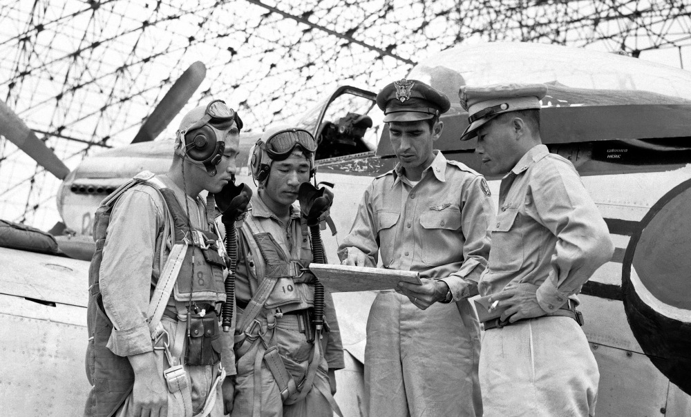 Lt. Col. Dean Hess, second from right, points out target areas on a map in 1950 as he briefs two American-trained South Korean pilots just before takeoff. Brig. Gen. Kim Chung Yui, chief of staff of the Korean air force, is at right. Rock Hudson played Hess in “Battle Hymn.”