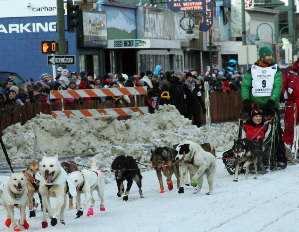 Musher Kelly Maixner, of Big Lake, Alaska, with a rider in his sled, participates in the ceremonial start of the Iditarod Trail Sled Dog Race in Anchorage, Alaska, on Saturday.