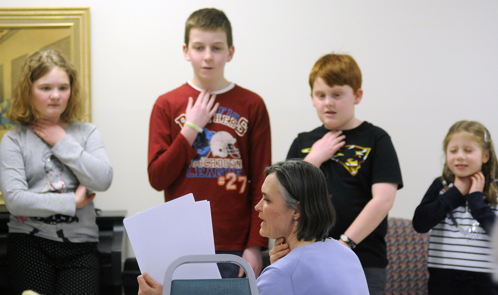 Karen Foust, the teacher for the Maine French Language Heritage Program, leads Augusta elementary school students enrolled in the program in a song Tuesday at the Chateau Cushnoc in Augusta.