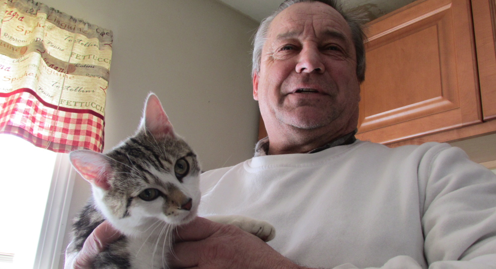William Rattenni holds his cat Floki, who kept a nearby woman trapped in her house for two hours Thursday.