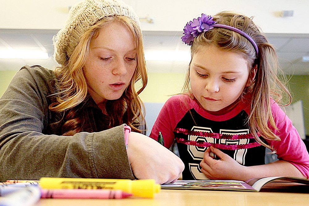 Kialeigh Marston, 17,  left, reads with Bayley Rafuse-Morse at Buxton Center Elementary School. Elementary school students  gain more reading skills and learn to enjoy reading, when Teen Trendsetters volunteers take time to read with them.