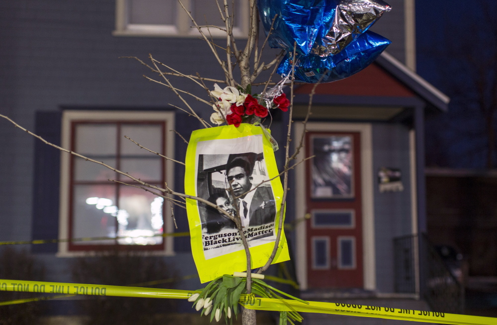 A makeshift memorial in front of a home cordoned off with barricade tape in Madison, Wis., pays tribute to a 19-year-old black man killed by police. Demonstrators marched Saturday to protest the killing.