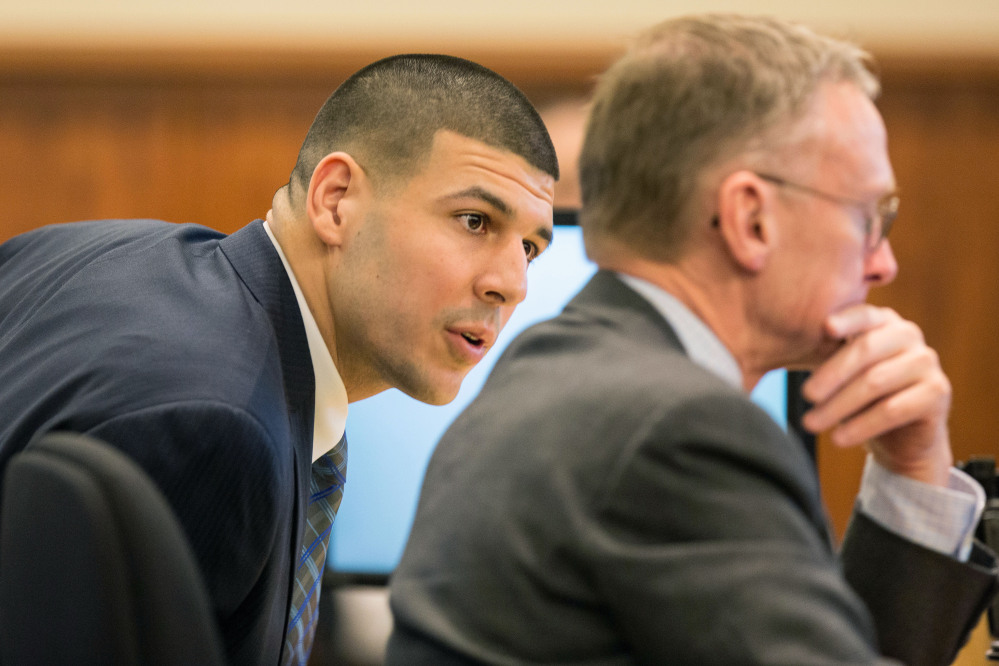 Aaron Hernandez speaks with his attorney Charles Rankin during the murder trial of the former New England Patriots player Monday at Bristol County Superior Court in Fall River, Mass.