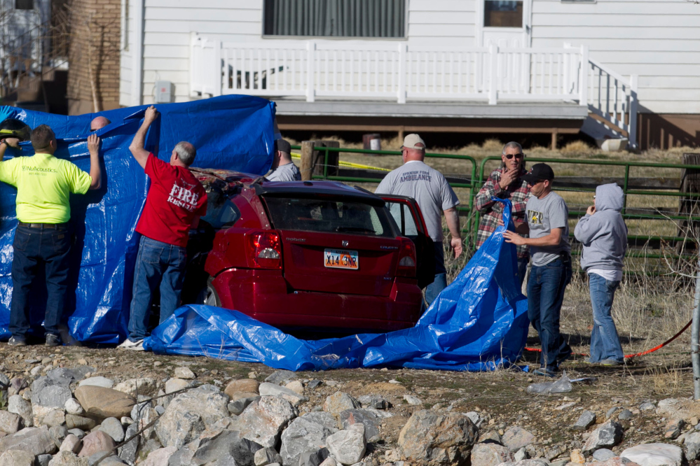 In this March 7, 2015 photo, officials respond to a report of car in the Spanish Fork River near the Main Street and the Arrowhead Trail Road junction in Spanish Fork, Utah.