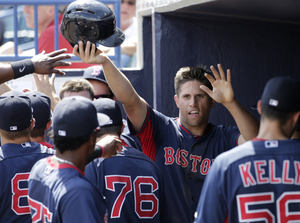 Garin Cecchini of the Boston Red Sox is welcomed back to the dugout after scoring on Travis Shaw’s two-run double in the fourth inning of a 10-6 victory against the New York Yankees at Tampa, Fla. Alex Rodriguez hit a home run for the Yankees in the game.