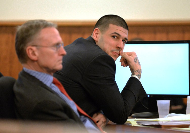 Former New England Patriots football player Aaron Hernandez sits with attorney Charles Rankin, as he tries to refrain from laughing during the testimony of Anthony Jerome, a former W Hotel Valet, during his trial Tuesday at Bristol County Superior Court in Fall River, Mass.