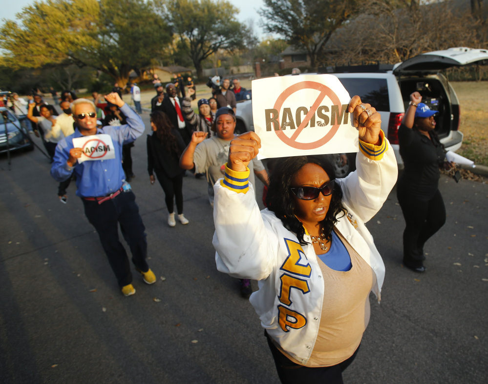 Darmita White holds a sign to protest outside of the home of Parker Rice, a University of Oklahoma student caught on video in a racist fraternity chant, in Dallas on Wednesday.