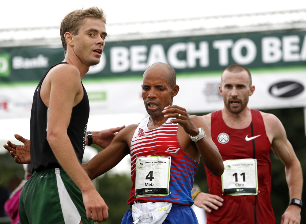 Will Geoghegan of Brunswick, left, is earning the right to hang with the best of the running world, including Meb Keflezighi, the Boston Marathon winner, at the Beach to Beacon road race in Cape Elizabeth last August.