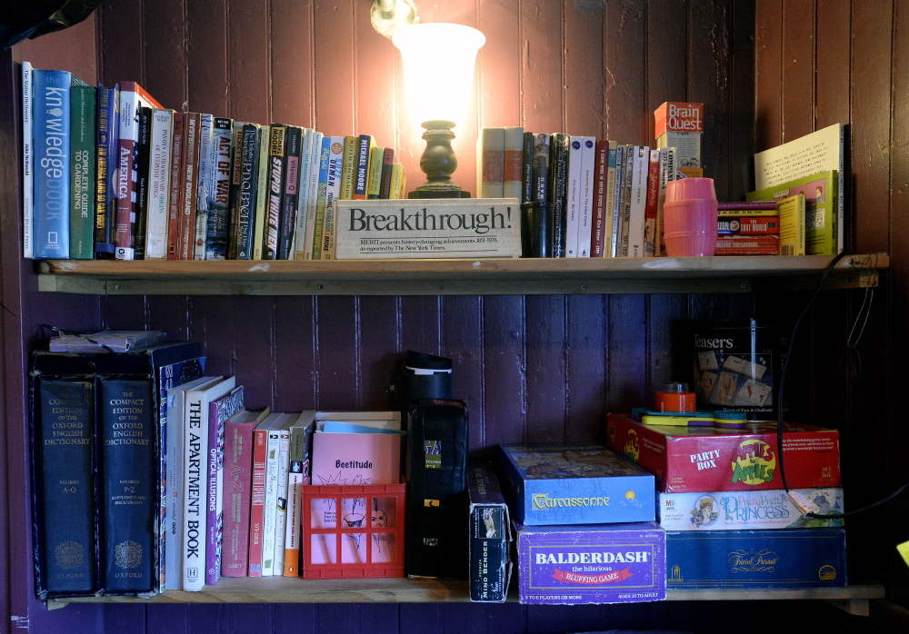 Books and games sit on the shelf at Mama’s CrowBar on Munjoy Hill. The CrowBar has an eclectic decor and an unusual mix of entertainment, much of it customer-generated.