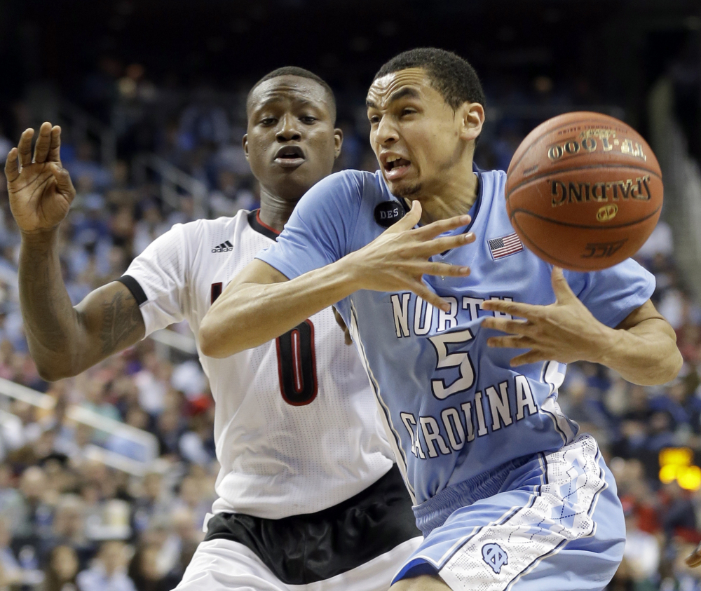 North Carolina’s Marcus Paige loses the ball as Louisville’s Terry Rozier defends during an Atlantic Coast Conference tournament quarterfinal in Greensboro, N.C. on Thursday night. Paige scored 13 points for the Tar Heels, who recovered from early missteps for a 70-60 win.
