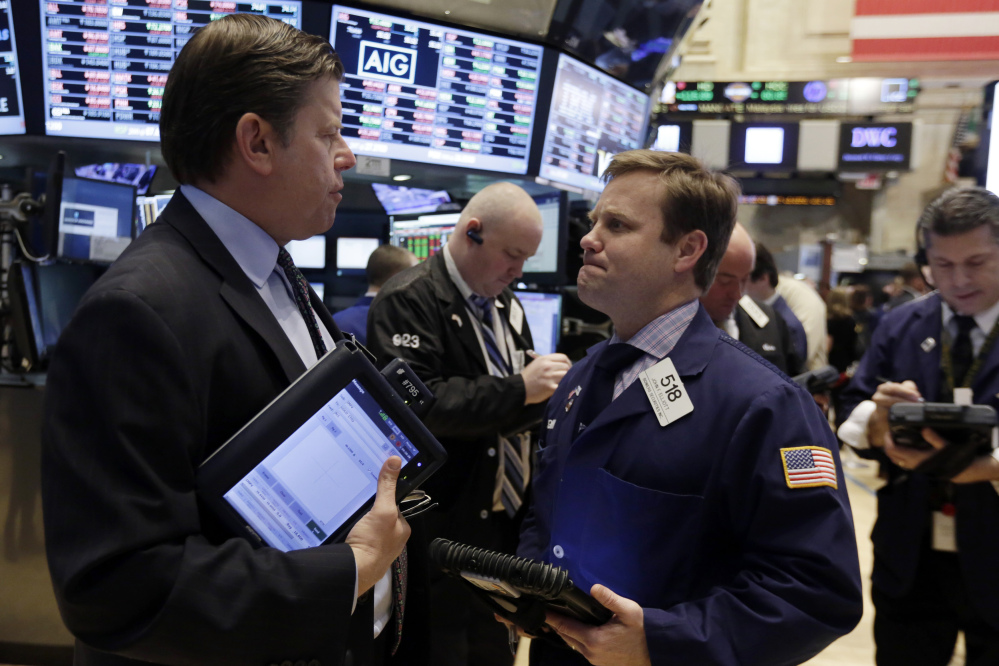 Traders Edward Schreier and John Elliott work on the floor of the New York Stock Exchange on Friday, when the Dow Jones industrial average fell 145.91 points.