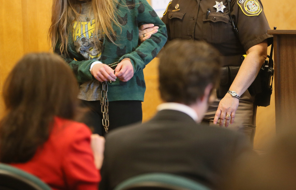 One of two girls, suspects in the Slender Man stabbing case, is escorted into court in Milwaukee on Friday. Her face is not shown because of her age.