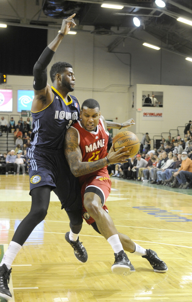 Romero Osby forces his way by Iowa’s Willie Reed for a layup during Friday night’s game at the Expo, won by the Red Claws in convincing fashion.