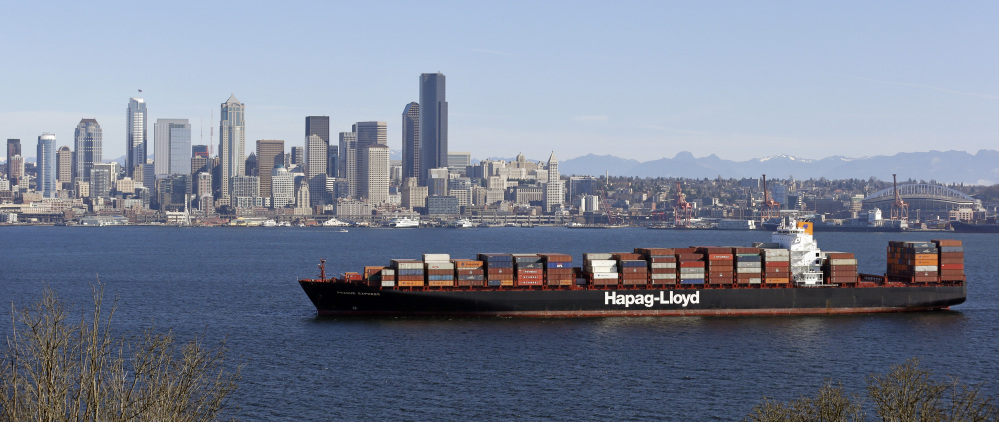 A container ship sits anchored in Elliott Bay in view of downtown Seattle. The United States is negotiating an ambitious trade agreement with 11 Pacific Rim countries that’s meant to ease barriers to fast-growing Asia-Pacific markets and streamline customs rules. The Associated Press