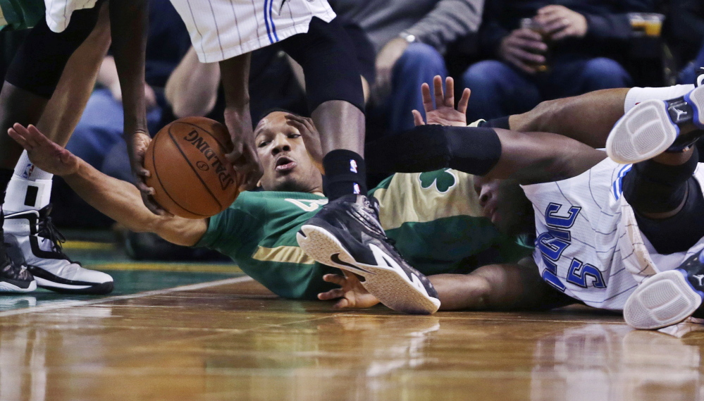 Celtics guard Avery Bradley reaches for the ball as he tangles with Orlando’s Victor Oladipo. Boston rallied from an 11-point deficit to beat the Magic, 95-88.