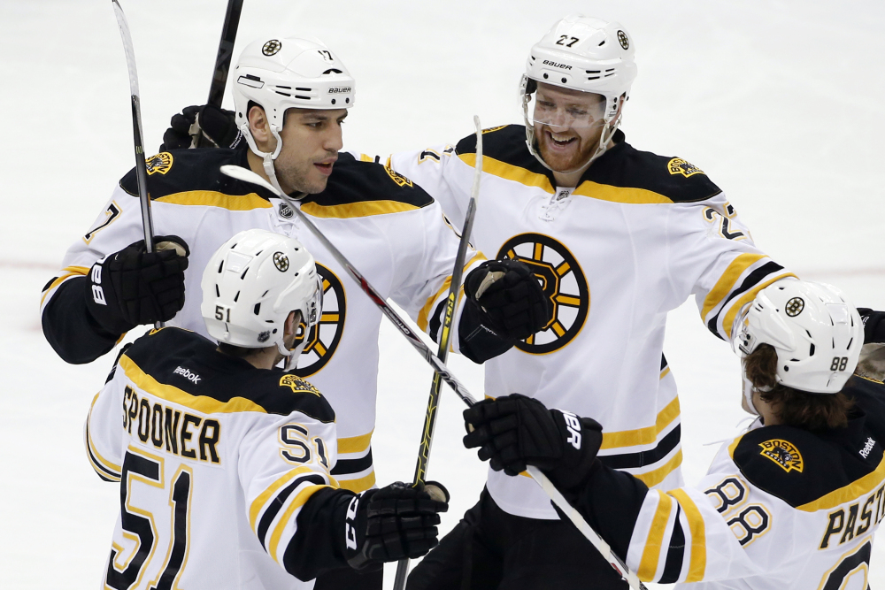 Milan Lucic, 17, of the Bruins celebrates his first-period goal with teammates Saturday in Pittsburgh. The Bruins added an empty-net goal in the final minute for a 2-0 win, their fifth straight.