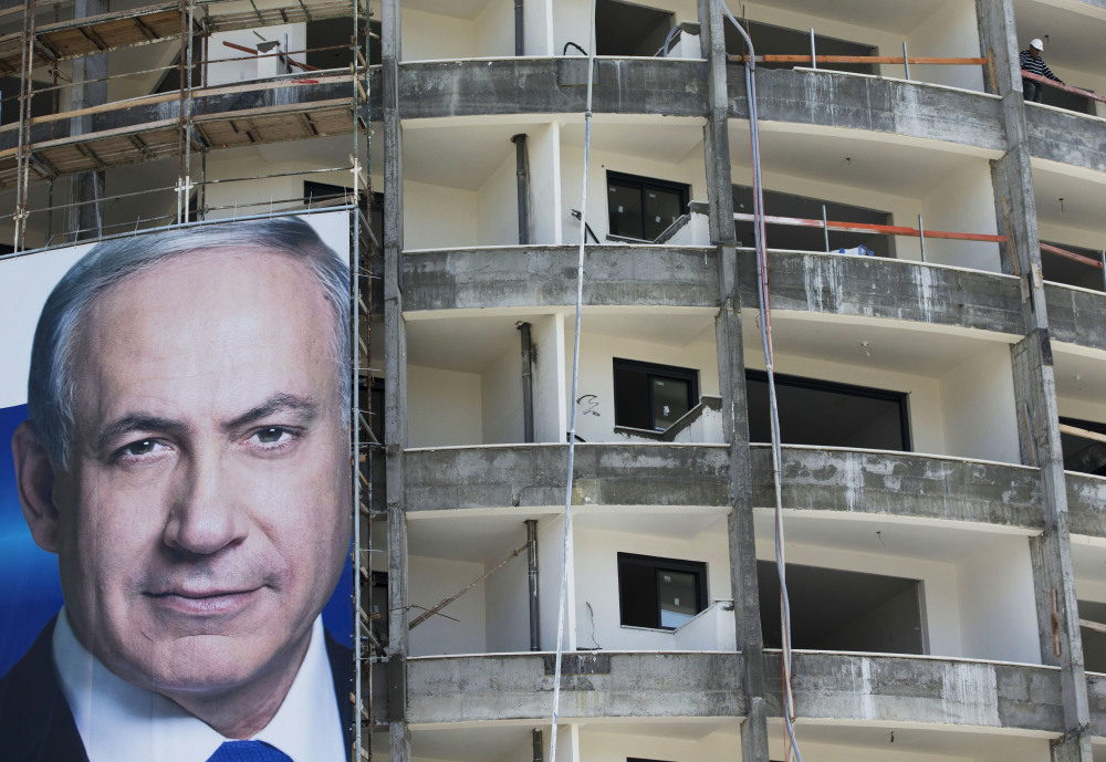 Prime Minister Benjamin Netanyahu’s campaign poster hangs at an Israel construction site in the run-up to Tuesday’s parliamentary elections.