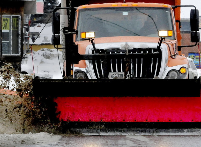 A Waterville Public Works plow truck pushes slush off streets in the city Sunday.
David Leaming/Staff Photographer