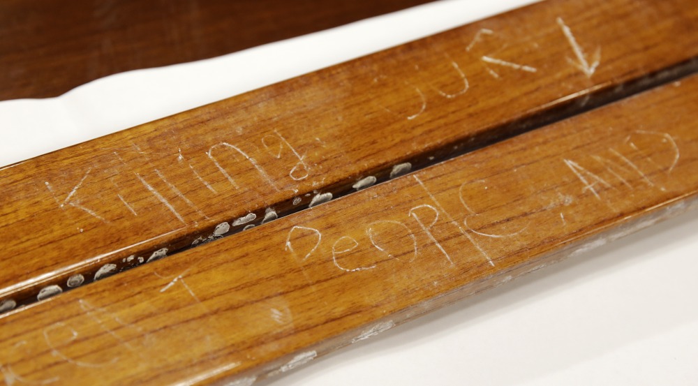 Wood from the power boat where Dzhokhar Tsarnaev was found hiding, etched with many words including “killing our people,” is displayed in a conference room at the John Joseph Moakley United States Courthouse in Boston on Tuesday. The wooden pieces were presented to a jury in Tsarnaev’s federal death penalty trial.