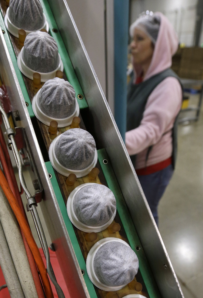 Single-serve coffee pods, significant because they are made of biodegradable materials, move on a conveyor at the Rogers Family Company in Lincoln, Calif. The  Rogers company is one of several coffee roasters who make single-serve coffee pods for use in Keurig’s Green Mountain single-serve brewing machines.