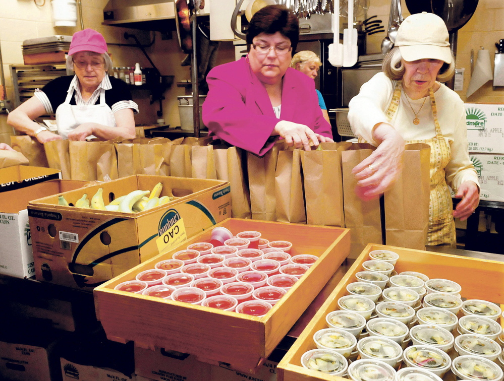 Linda Fossa, center, director of health and welfare for the city of Waterville, joined volunteers including Cheryl Gulliver, left, and Helen Cole to pack meals at the Muskie Center in Waterville on Thursday.