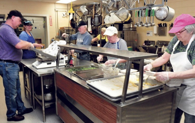 Volunteers at the Muskie Center in Waterville prepare dinners for the Meals on Wheels program Wednesday. From left are John Veilleux, Victoria Veilleux, Vaughn Tuttle, Rita Tuttle and Cheryl Gulliver.