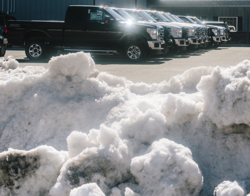 Trucks and snow vie for space Thursday at Arundel Ford. The president of the Maine Automobile Dealers Association said the winter had a “disruptive effect on sales volumes.”