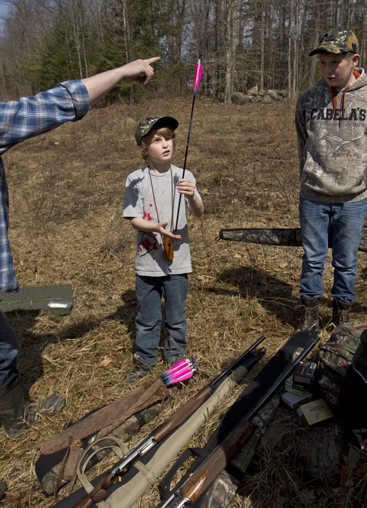 A youngster learns to balance an arrow at a hunting camp last year in Casco. The sponsorship of a new bill to designate a Youth Bear Hunting Day raises a question of conflict of interest, a reader says.