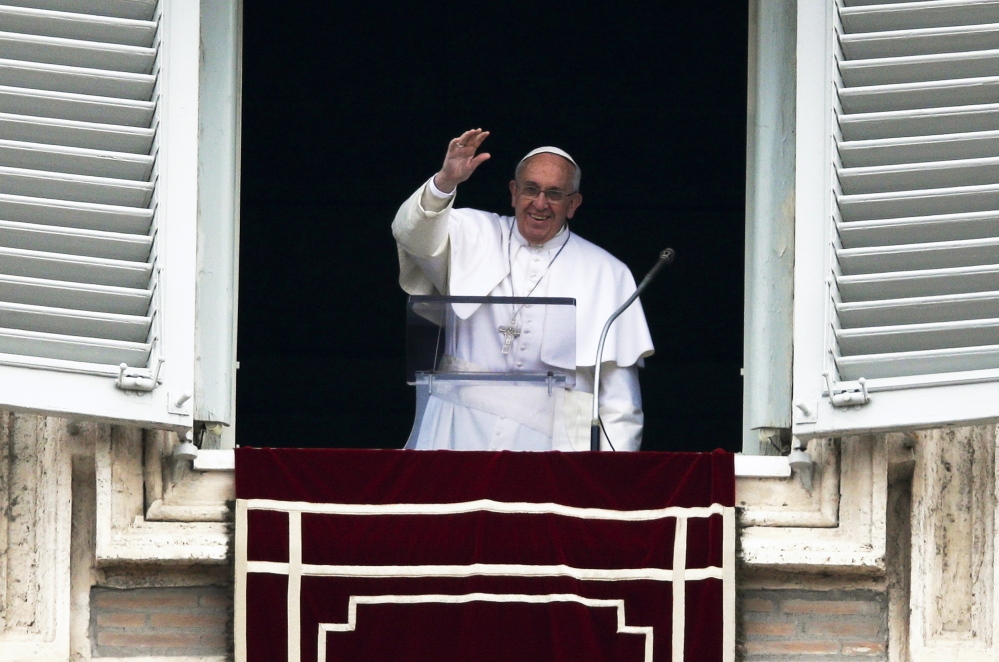 Pope Francis waves as he leads the Angelus prayer from the window of the Apostolic Palace in St. Peter’s Square at the Vatican on Sunday.