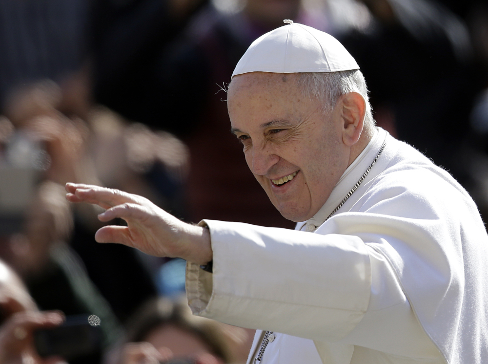 Pope Francis waves to the faithful as he arrives in St. Peter’s Square for his weekly general audience Wednesday.
