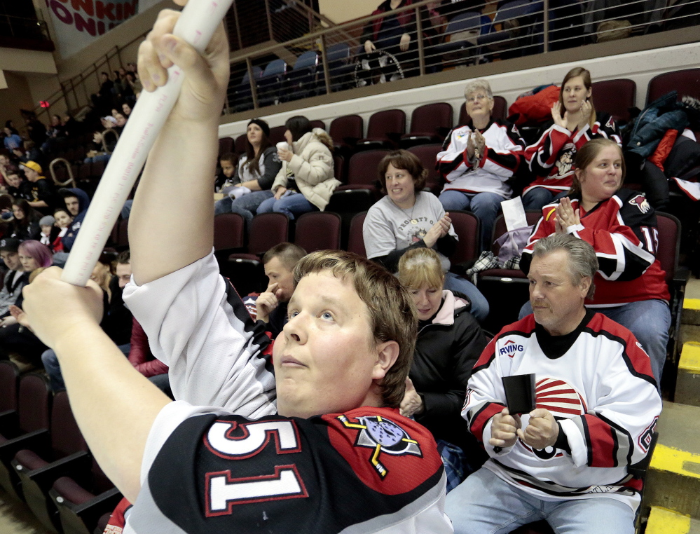 Andrew Hart of South Portland waves a flag as the Portland Pirates take the ice against the Hershey Bears at Cross Insurance Arena on Friday night. Hart calls the Pirates’ new affiliation with the Florida Panthers “a very welcome change.”