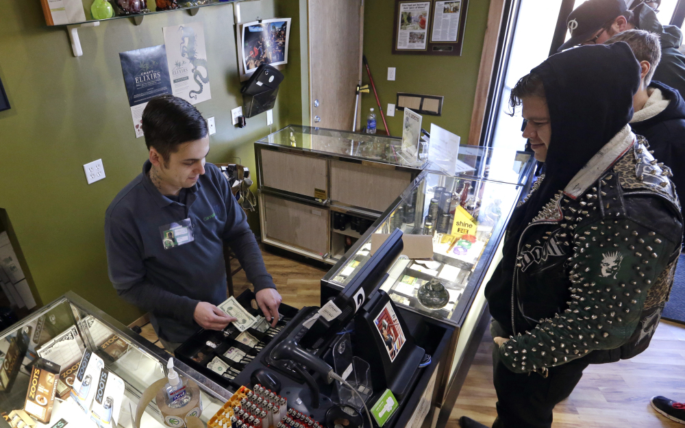 Cannabis City clerk John Golby, left, helps customers looking for marijuana products at the shop in Seattle. For the first time, most Americans want to legalize marijuana, according to the 2014 General Social Survey.