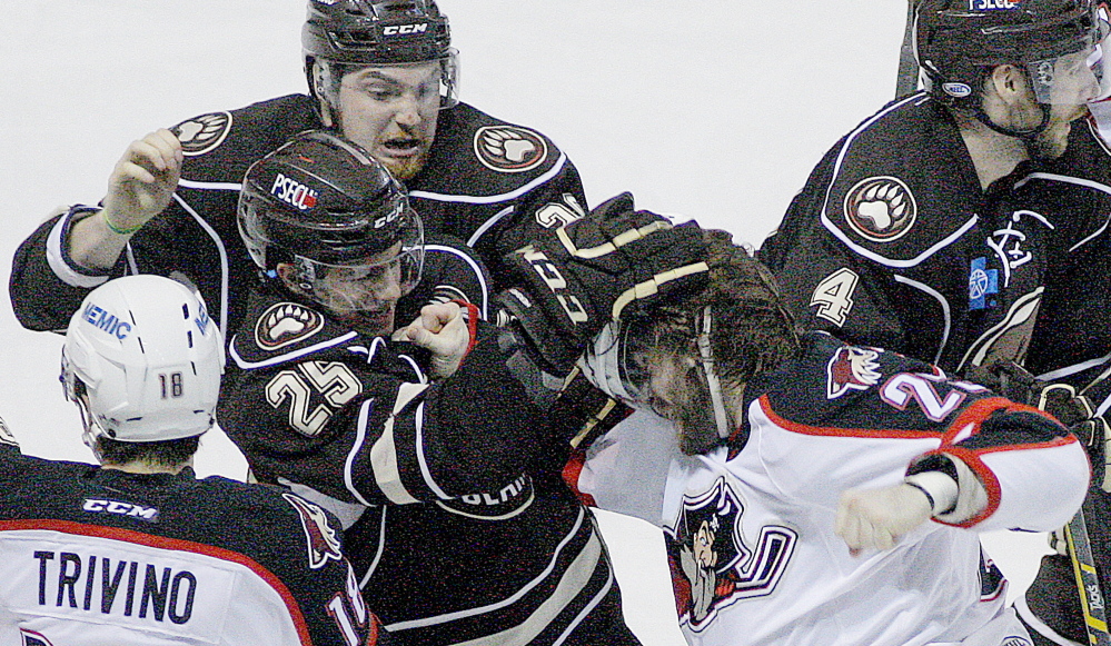 Hershey’s Connor Carrick tears at the helmet of the Pirates’ Eric Selleck during a second-period fight Friday night, while the Bears’ Liam O’Brien, top, tries to intervene.