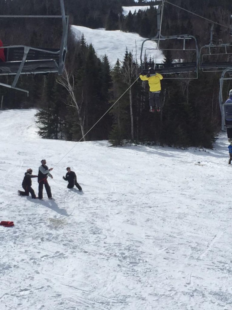 Sugarloaf employees work to lower a skier down from the King Pine quad chairlift Saturday after it rolled back several hundred feet.
Photo courtesy of WCSH