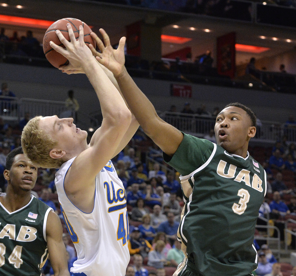 UAB’s Chris Cokley, right, attempts to tip the ball away from UCLA’s Thomas Welsh in the first half of Saturday’s NCAA tournament game at Louisville, Ky. The Bruins won 92-75 to reach the Sweet 16.