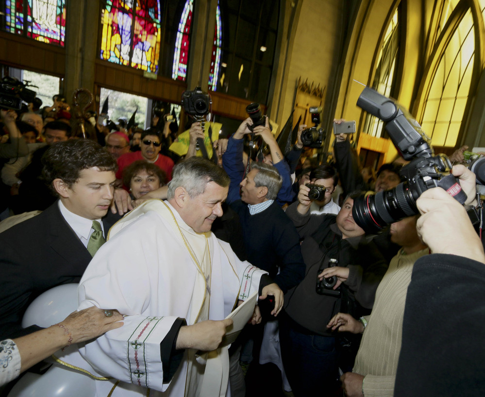 The Rev. Juan Barros is escorted into a cathedral for his ordination as bishop Saturday in Osorno, Chile, in a ceremony cut short by protesters who accuse him of covering up sex crimes by a priest disciplined by the Vatican.