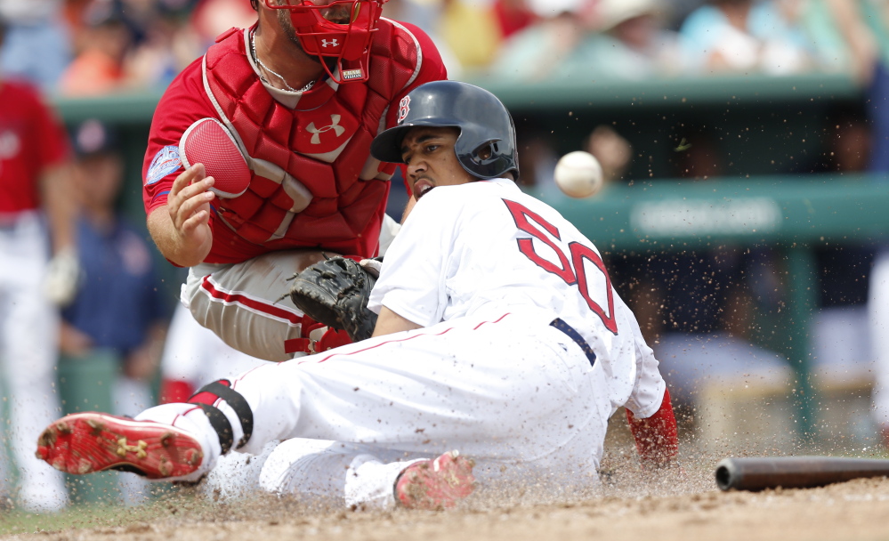Boston’s Mookie Betts slides home with an inside-the-park homer, just ahead of the throw to Philadelphia Phillies’ catcher Cameron Rupp in the third inning of Sunday’s spring training game in Fort Myers, Fla.