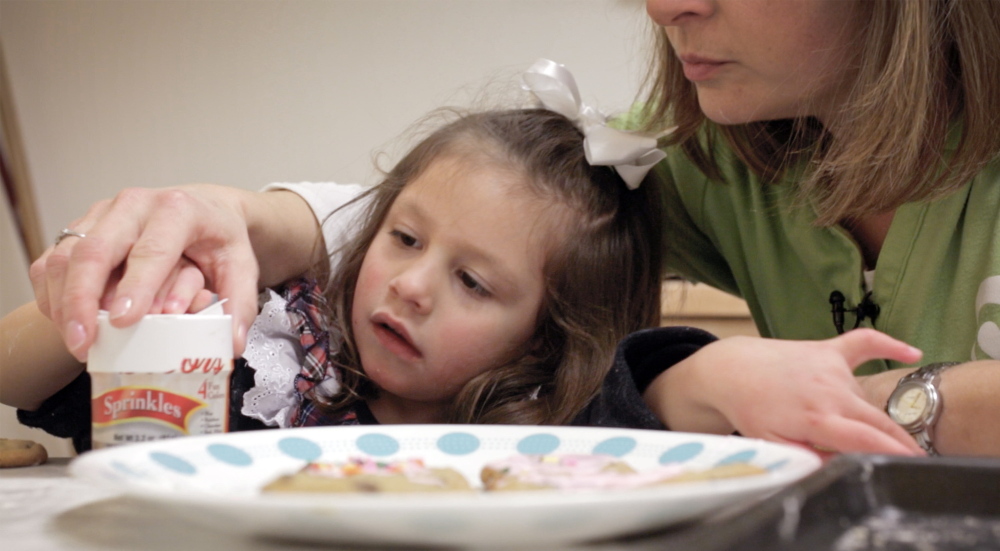Zoey Houston, 3, makes cookies with occupational therapist Amy Smith at the New England Rehabilitation Hospital in Portland. Smith is trying to break Zoey’s habit of using only her right hand.