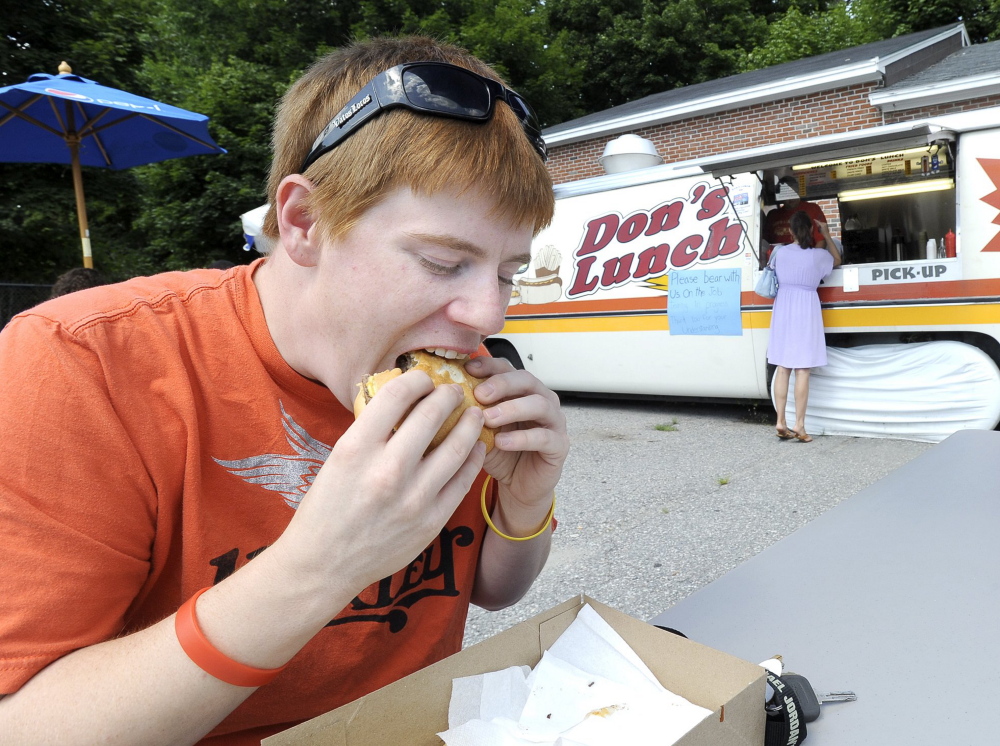 Meagan Garland of Westbrook bites into a “Big One” in August 2012 at Don’s Lunch. The trademark van has now been moved from its lot and is being stored until sold.