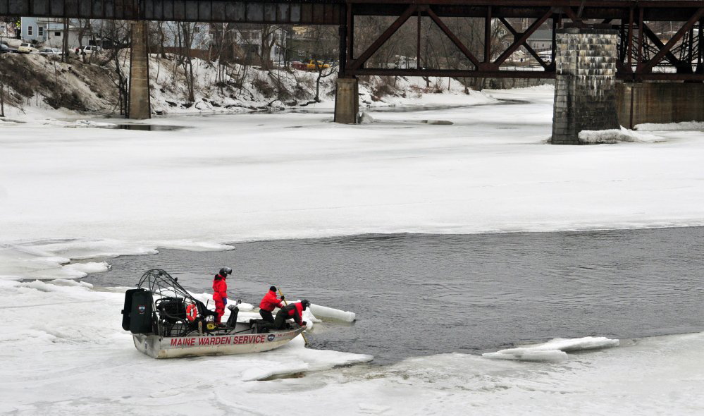 Wardens on an airboat search the Kennebec River for a woman who disappeared under the ice between the Calumet Bridge at Old Fort Western and the railroad trestle on Saturday in Augusta.