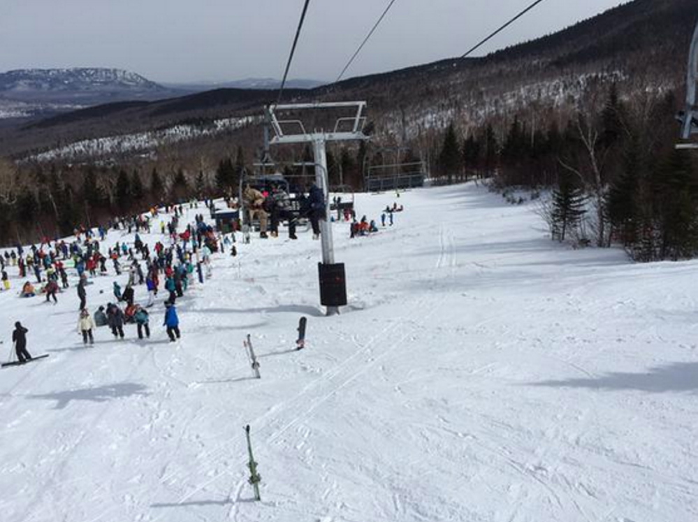 Skiers and Ski Patrol members gather beneath the King Pine chairlift at Sugarloaf Saturday after a malfunction that caused the lift’s chairs to reverse for more than 400 feet.