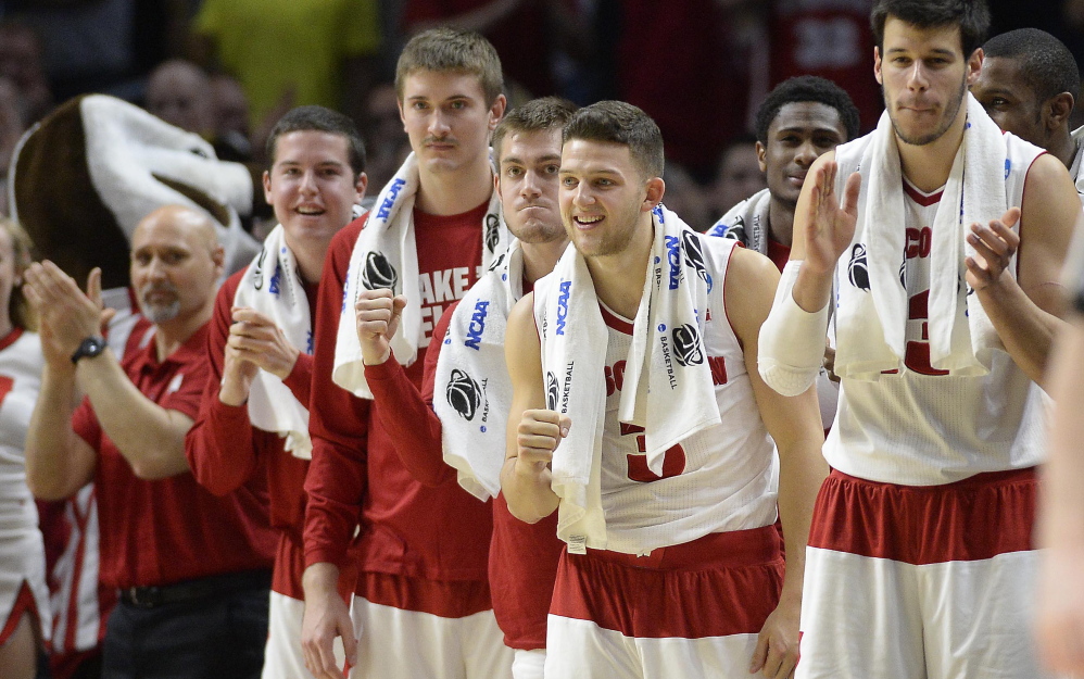 Wisconsin players start the fist-pumping on the bench near the end of the Badgers’ win over North Carolina, which earned them a spot in the Elite Eight.