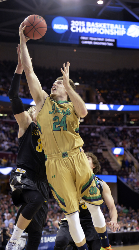 Pat Connaughton of Notre Dame heads to the basket against Ron Baker of Wichita State during the first half of their NCAA basketball tournament game Thursday night. The Irish rolled into the Elite Eight, pulling away for an 81-70 victory at Cleveland.